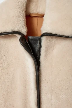 LANGER MANTEL AUS SHEARLING MIT LEDERDETAILS