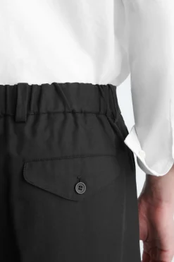 LOCKERE, SCHMAL ZULAUFENDE HOSE MIT FALTEN